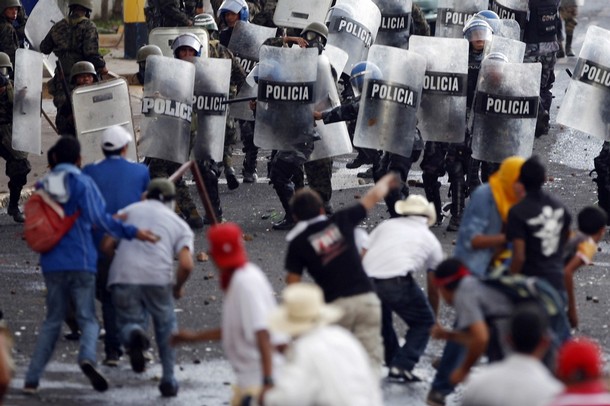 Supporters of Honduras' President Manuel Zelaya clash with police near the presidential residence in Tegucigalpa June 29, 2009. Honduras came under pressure on Monday to reinstate ousted Zelaya as many Latin American leaders agreed to withdraw envoys, Washington said the ouster was illegal and protesters took to the streets. REUTERS/Edgard Garrido (HONDURAS POLITICS CONFLICT IMAGES OF THE DAY)