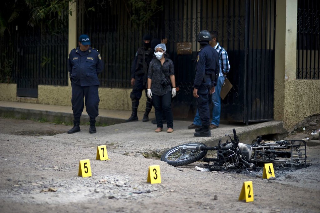 Forensic personnel work on the scene where an alleged gang member was killed by the police after a shooting at El Pedregal neighborhood in Tegucigalpa, on November 21, 2013. Honduras, considered the world's most violent country with a murder rate of 85,5 per 10,000 of population, will hold general elections next November 24th. AFP PHOTO/ Jose CABEZAS        (Photo credit should read Jose CABEZAS/AFP/Getty Images)