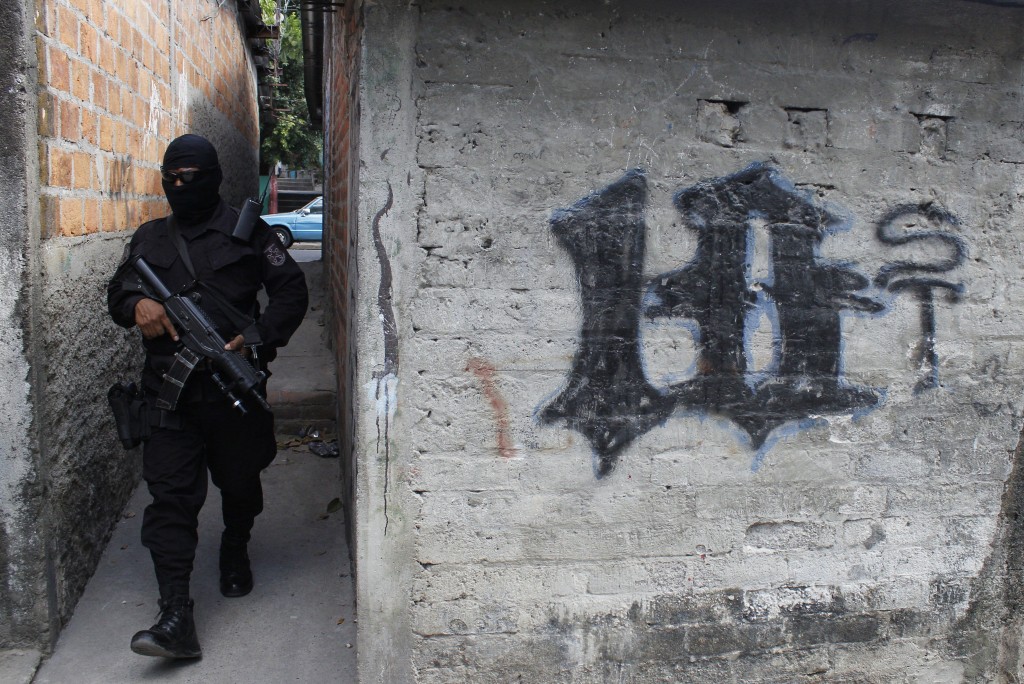 En esta imagen del 5 de abril de 2016, un policía armado y enmascarado patrulla un barrio controlado por pandillas en San Salvador, en El Salvador. Pandillas muy violentas declararon una campaña contra la policía en el país centroamericano en respuesta a una operación del gobierno iniciada el año pasado (AP Foto/Alex Peña)
