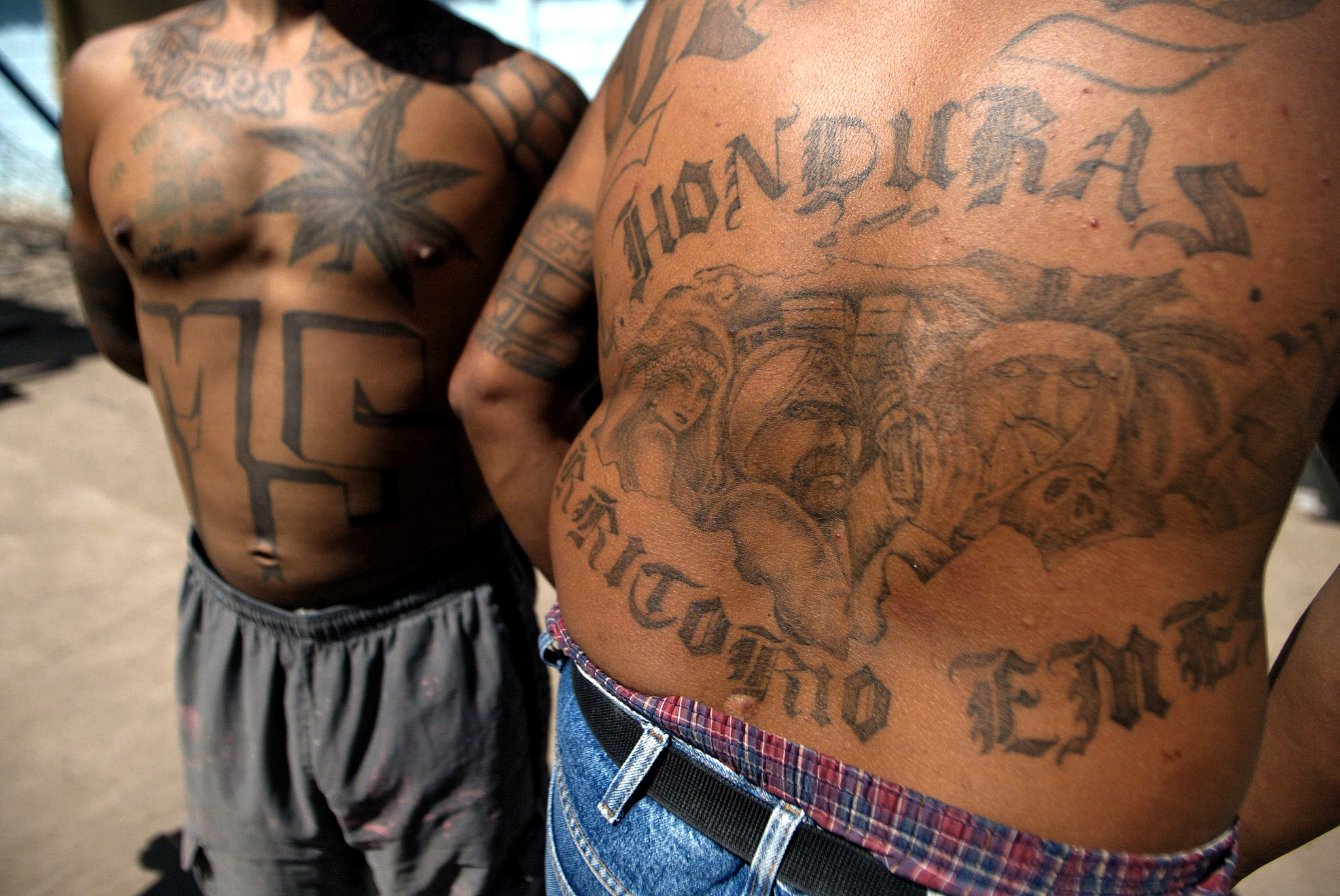 Two unidentified members of the Mara Salvatrucha "MS-13" (juvenile gang) show their tatoos in the unit where they are kept imprisioned in the National Penitentiary in Tamara, 30km north of Tegucigalpa, 01 February 2006. AFP PHOTO/Elmer MARTINEZ
