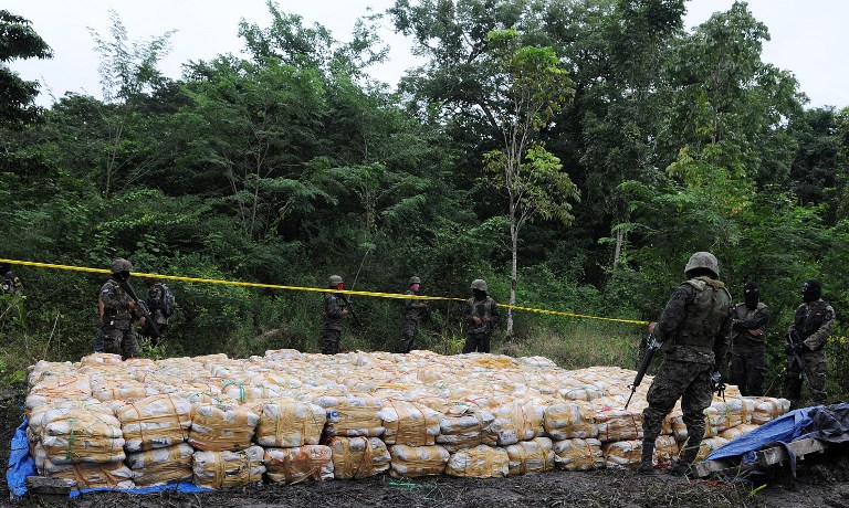 Honduran soldiers guard 15 tons of seized cocaine in Patagallina, Santa Rita municipality, Yoro department, some 300 kms north of Tegucigalpa, on November 29, 2012. The drug -found in an underground vault that operated as a laboratory- was divided into 344 packs.