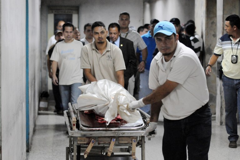 The body of Orlan Chavez, Fiscal Unit Against Money Laundering, who was killed by gunmen, is carried on stretcher in Tegucigalpa on April 18, 2013. The homicide rate in Honduras is the highest in the world, with 85.5 murders per 100,000 inhabitants, despite the "security policy" implemented by the government of President Porfirio Lobo. AFP PHOTO / Orlando SIERRA.