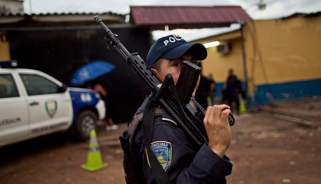 https://elpulso.hn/wp-content/uploads/2018/10/06-06-13-National-Police-officer-behind-weapon-during-operative-police-station-El-Mayoreo-markert-in-Tegucigalpa-Honduras-Credit-Esteban-Felix-AP_13060618147.jpg